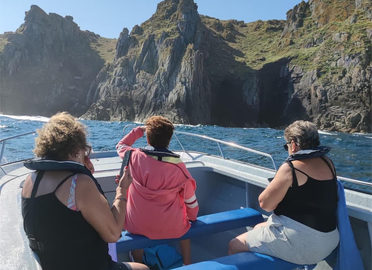 Grupo en barco contemplando los acantilados de la Costa da Morte con Surca